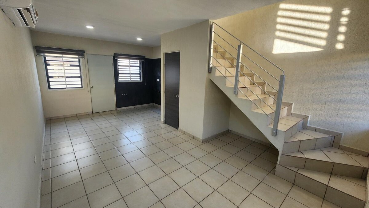 Sala de estar con escalera moderna y espacios integrados